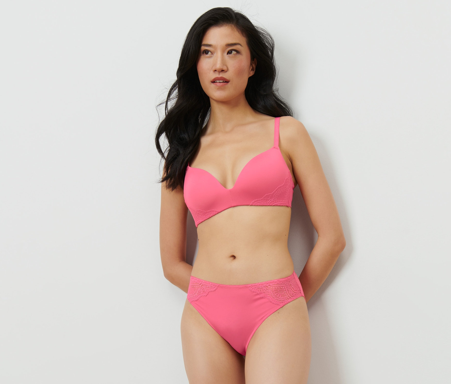 Eine Frau posiert in einem pinken BH und 2 Slips, pink.