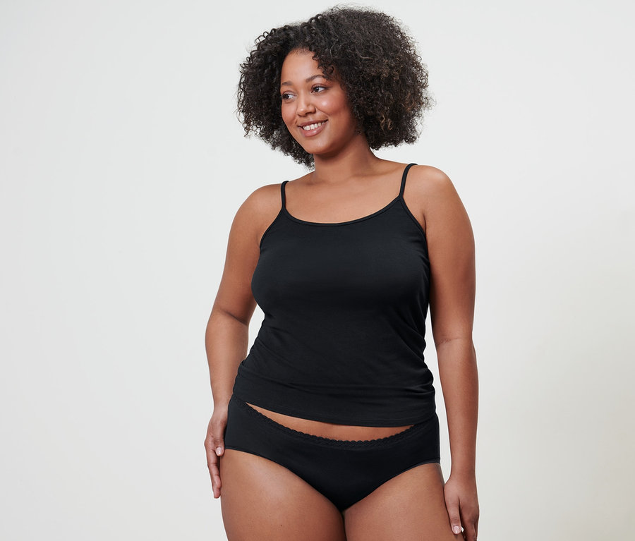 Frau trägt 5 schwarze Pantys und 2 Spaghetti-Hemdchen.