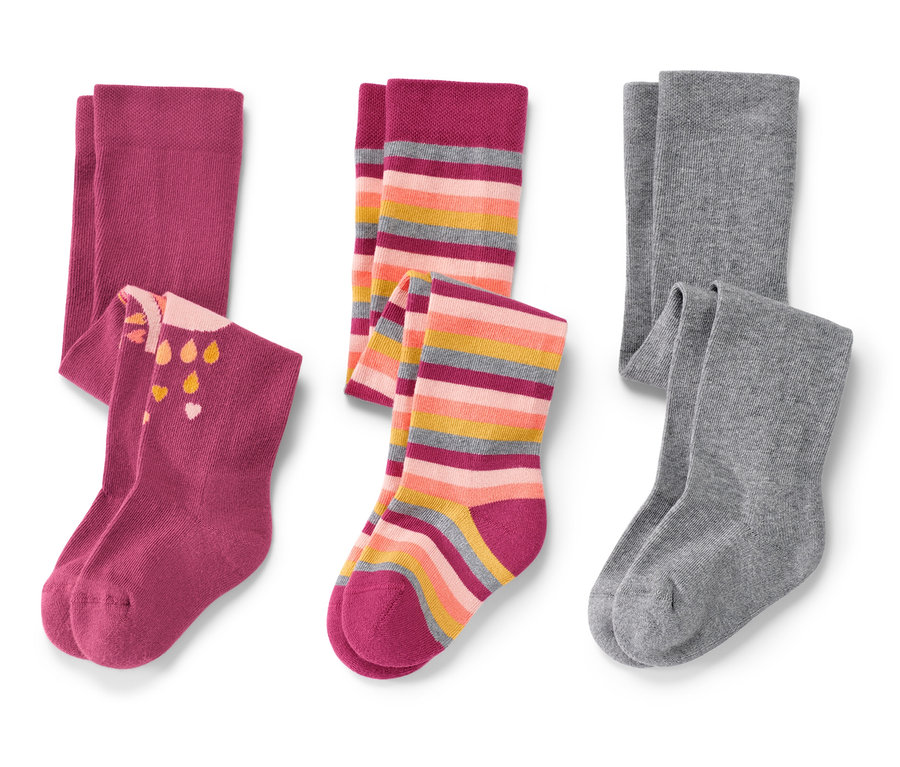 Drei Paar Babystrumpfhosen: ein Paar rosa mit Aufdruck, ein Paar bunt gestreift und ein Paar grau.