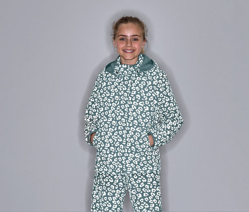 Mädchen posiert in einer Thermo-Regenjacke mit reflektierenden Elementen und Leopardenmuster.