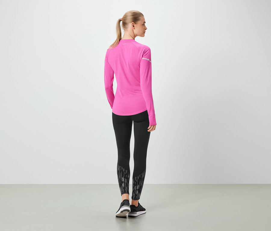 Frau mit dem Rücken zur Kamera trägt ein pinkes Langarmshirt und schwarze Leggings.