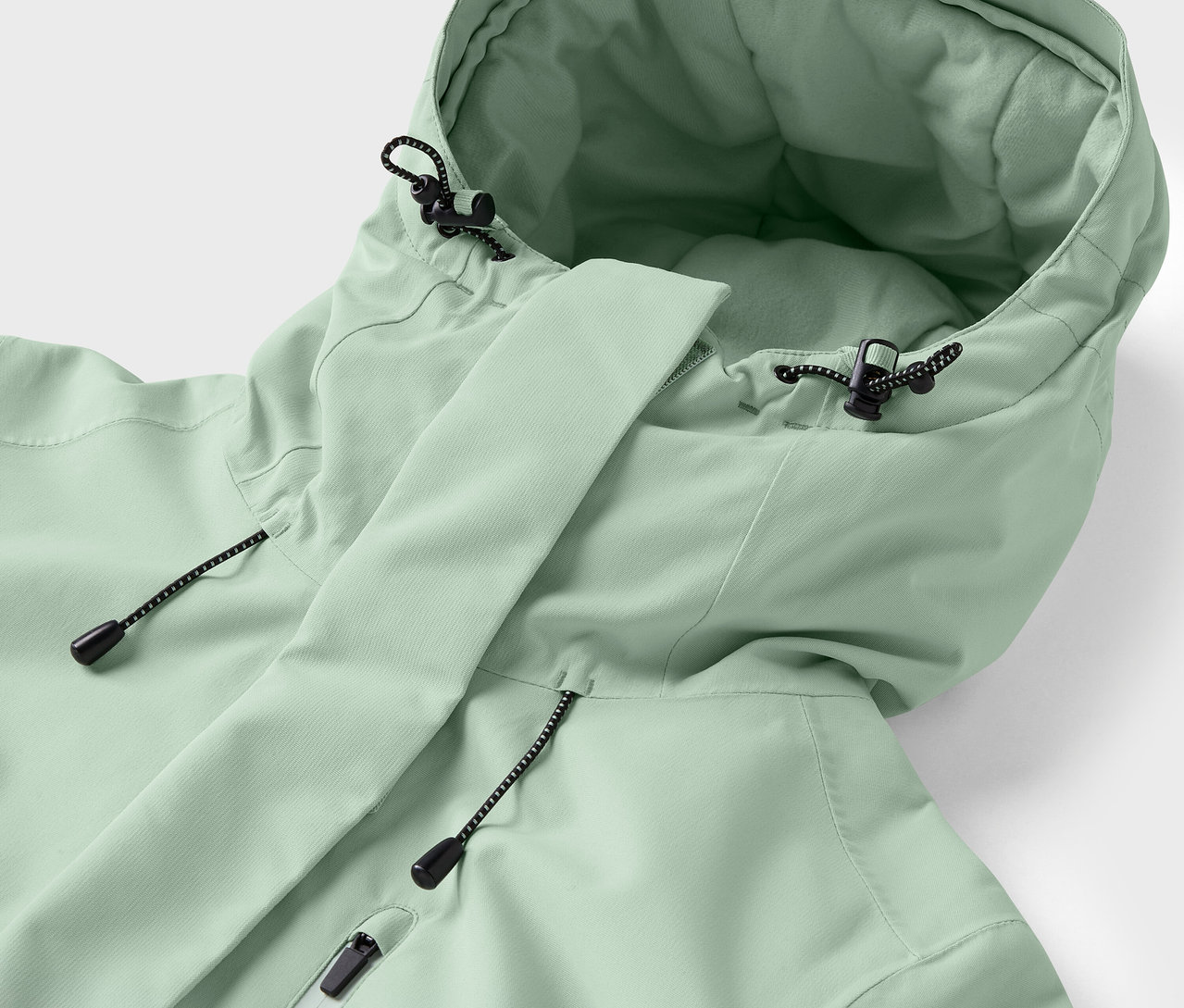 Detailaufnahme einer hellgrünen Jacke mit Kapuze und Kordelzügen.