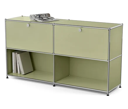 Grüner modularer Schrank mit vier Fächern, von denen zwei Türen haben. Auf der Oberseite liegen eine Brille und eine Zeitschrift.