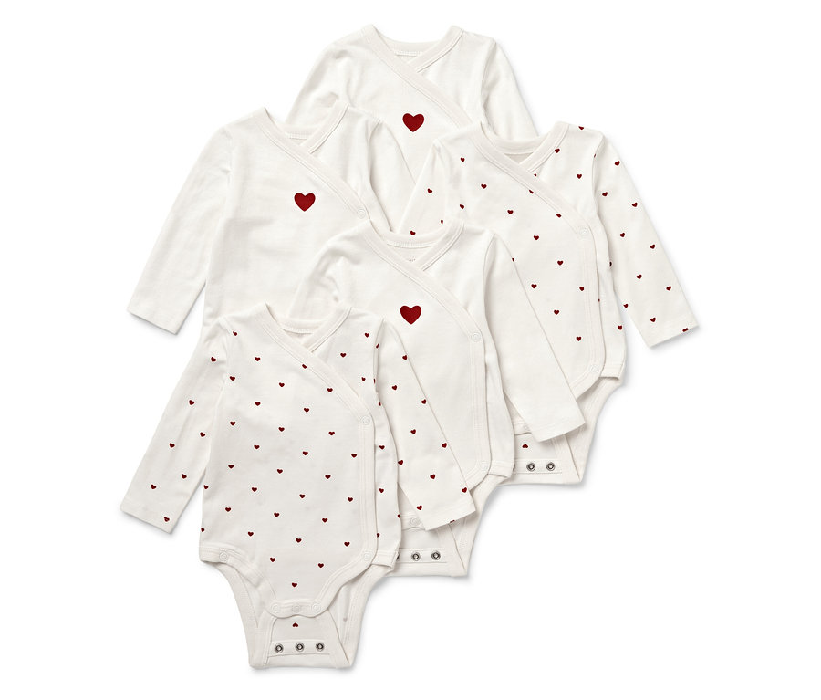 Fünf weiße Baby-Wickelbodys mit langen Ärmeln und roten Herzen.