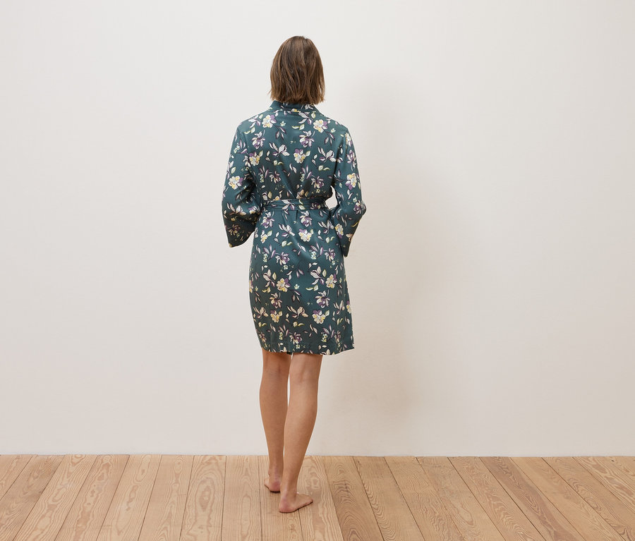 Frau von hinten in einem blumigen Morgenmantel.