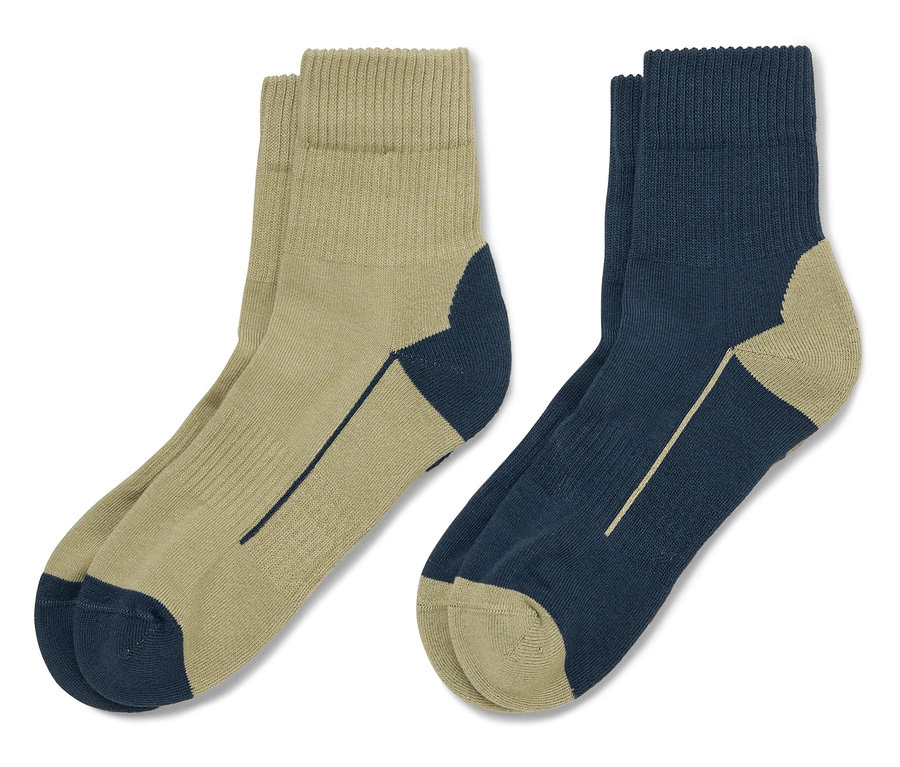 Zwei Paar Socken liegen auf einem weißen Hintergrund, ein Paar ist khaki mit marineblauen Akzenten, das andere marineblau mit khaki Akzenten.