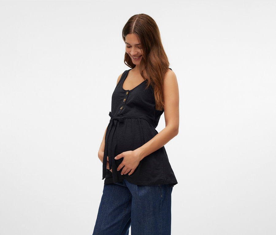 Frau hält ihren Bauch und trägt ein schwarzes MAMALICIOUS Stilltop »MLEVI LIA« und weite Jeans.