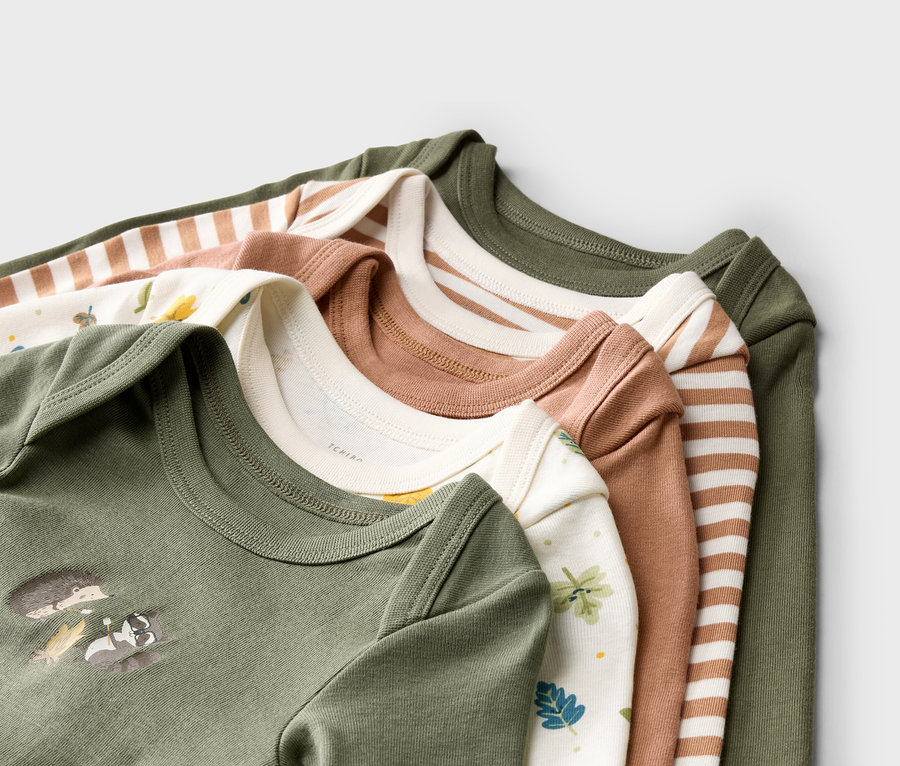 Fünf langärmlige Babybodys liegen übereinander, mit verschiedenen Mustern und Farben wie Olive, Braun gestreift und Blätter.