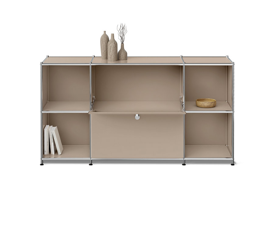 Ein hellbraunes, modulares Regal mit Chromrahmen, bestehend aus drei Spalten und zwei Reihen. Das untere mittlere Fach hat eine Klapptür. Oben stehen drei dekorative Vasen, links unten drei weiße Bücher und rechts oben eine kleine Holzschale.