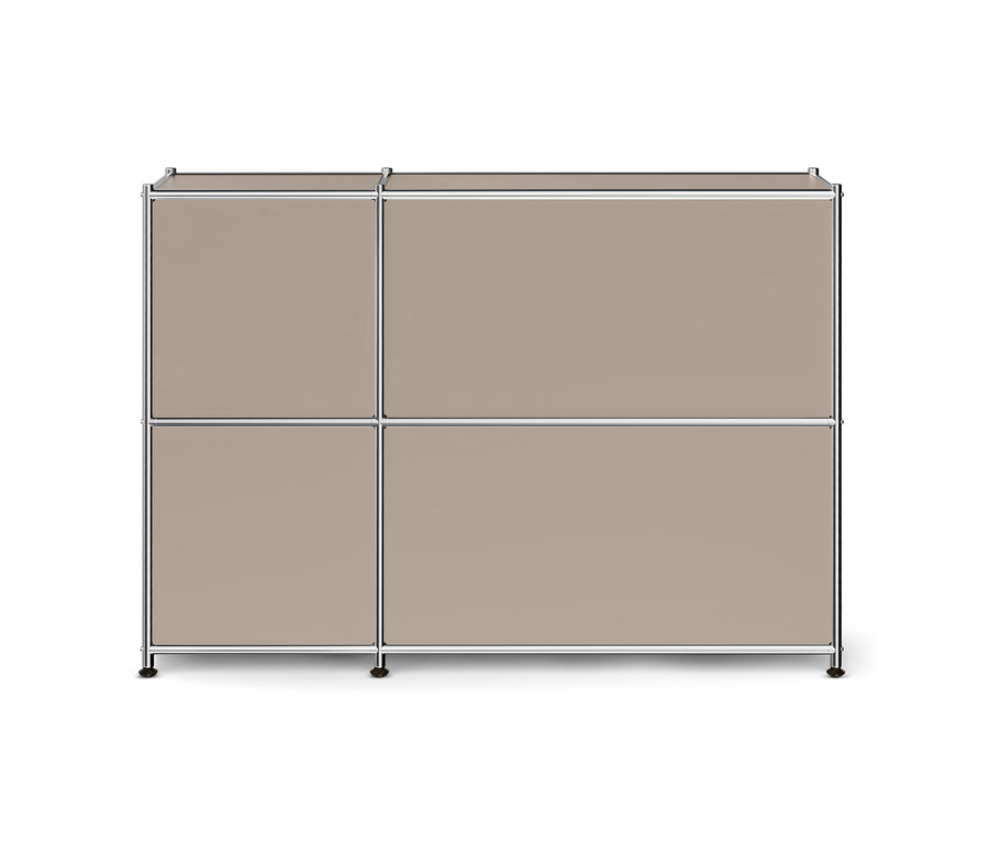 Ein modulares Möbelstück mit vier rechteckigen Paneelen in Beige-Taupe, umrahmt von silbernen Metallstangen. Das Möbelstück ist zwei Reihen hoch; die linke Spalte hat zwei schmalere Paneele, die rechte Spalte zwei breitere Paneele, alle auf kleinen dunklen Füßen stehend.