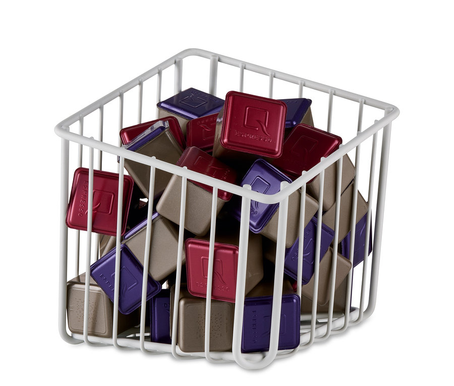 Ein weißer Kapselkorb gefüllt mit roten, violetten und braunen Kapseln.