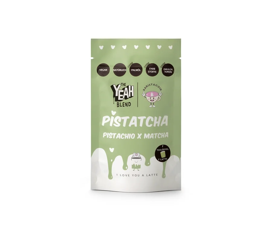 Eine hellgrüne Standbodenverpackung von The Yeah Blend - Pistatcha Matcha - 100 g. Die Packung zeigt Texte, die darauf hinweisen, dass sie vegan, natürlich und frei von Palmöl, Farbstoffen und Emulgatoren ist, zusammen mit einem 'Baristacoin'-Logo und einer Latte-Grafik mit dem Text 'I LOVE YOU A LATTE'.