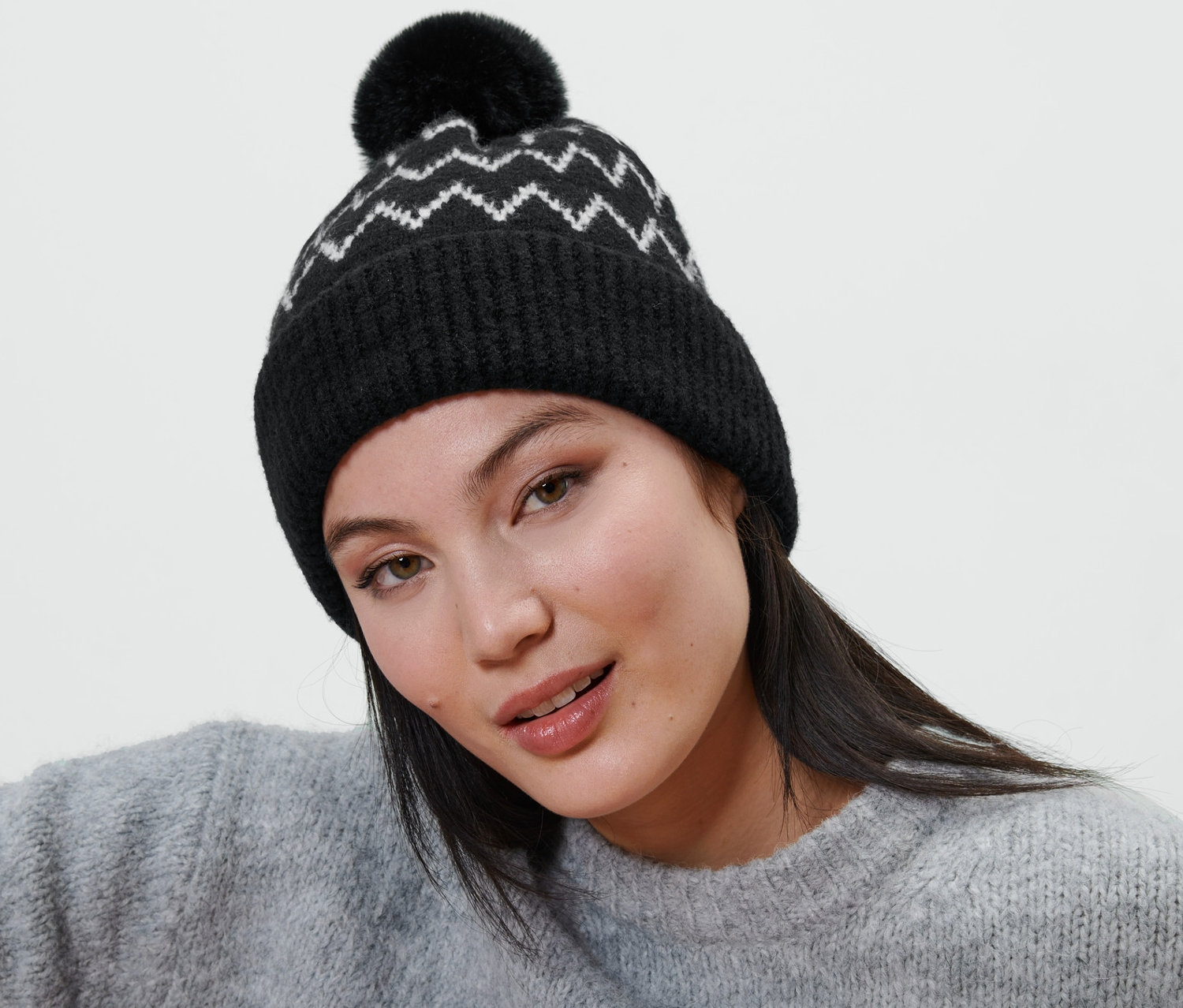 Frau trägt eine Strickmütze mit Bommel.