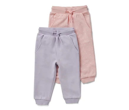 Zwei Baby-Sweathosen: eine helllila und eine rosa mit weißen Punkten.