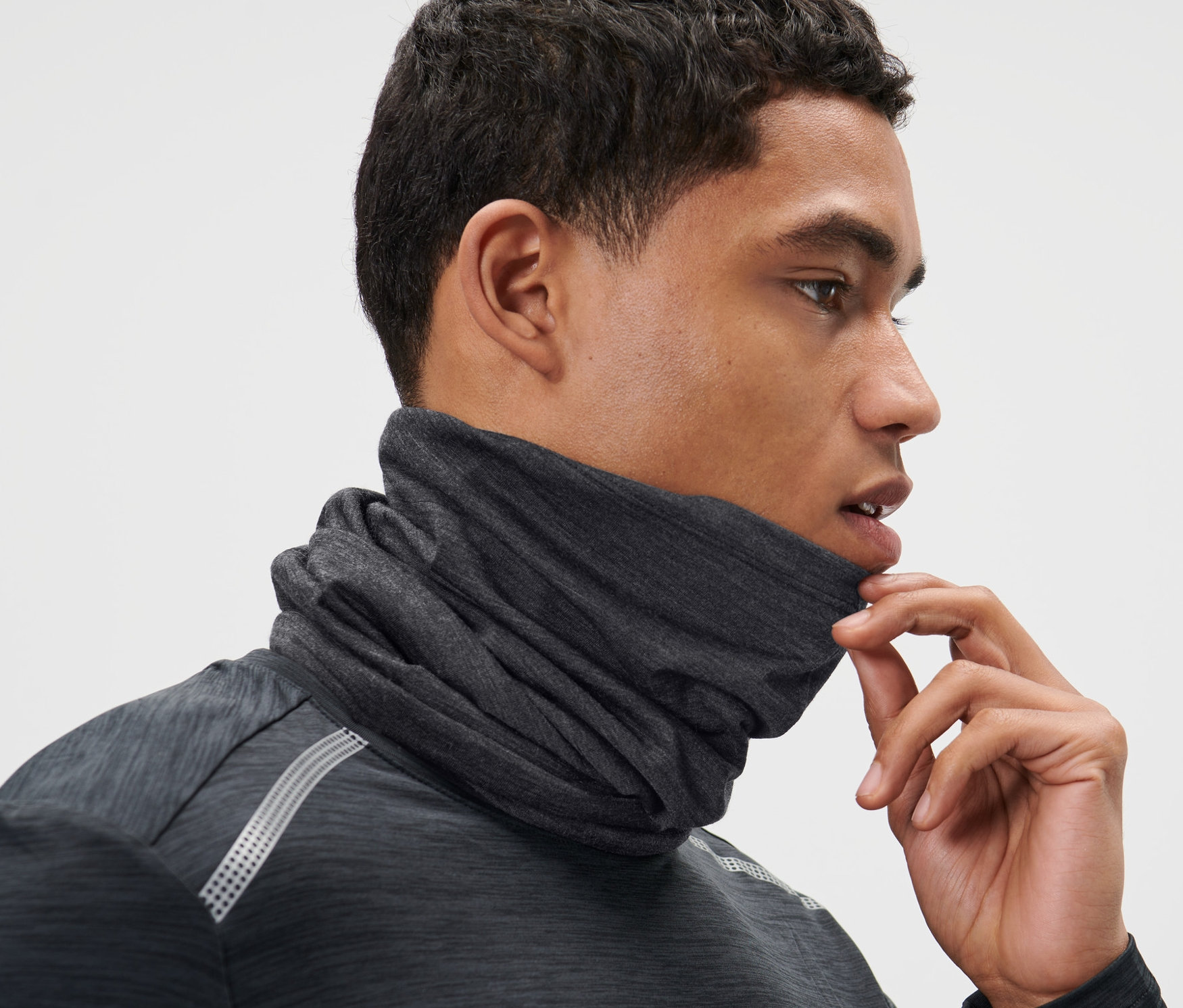 Mann richtet Multifunktionstuch mit Merinowolle am Hals.