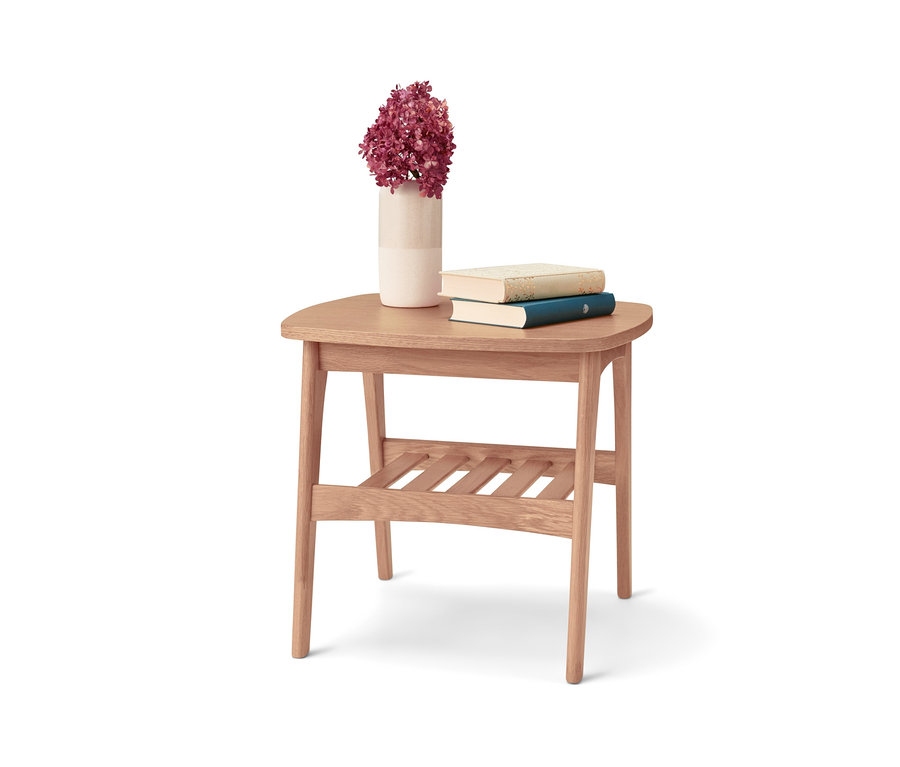 Blumen, zwei Bücher und eine Vase auf einem kleinen Tisch.