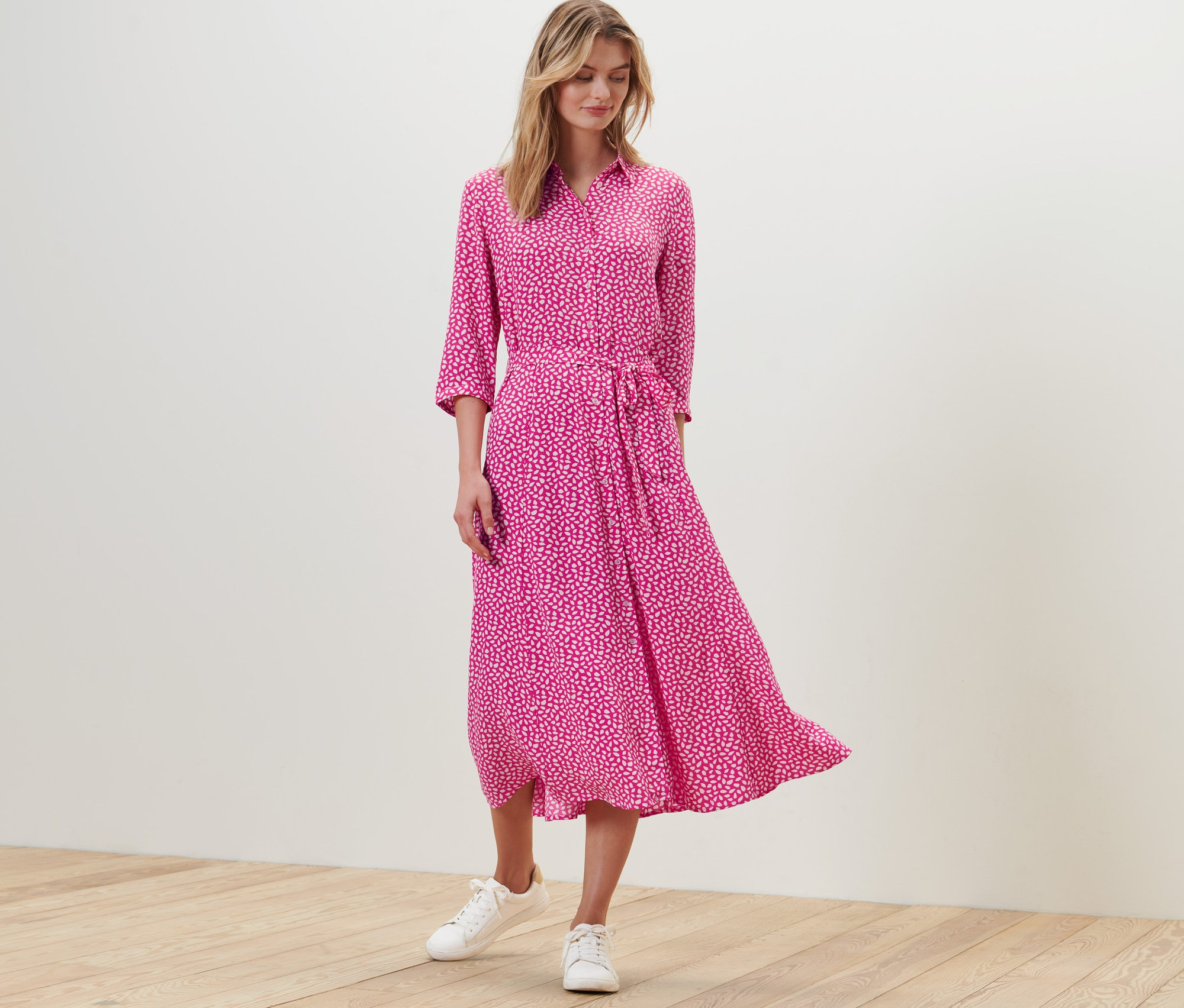 Eine Frau steht und trägt ein bedrucktes Hemdblusenkleid.