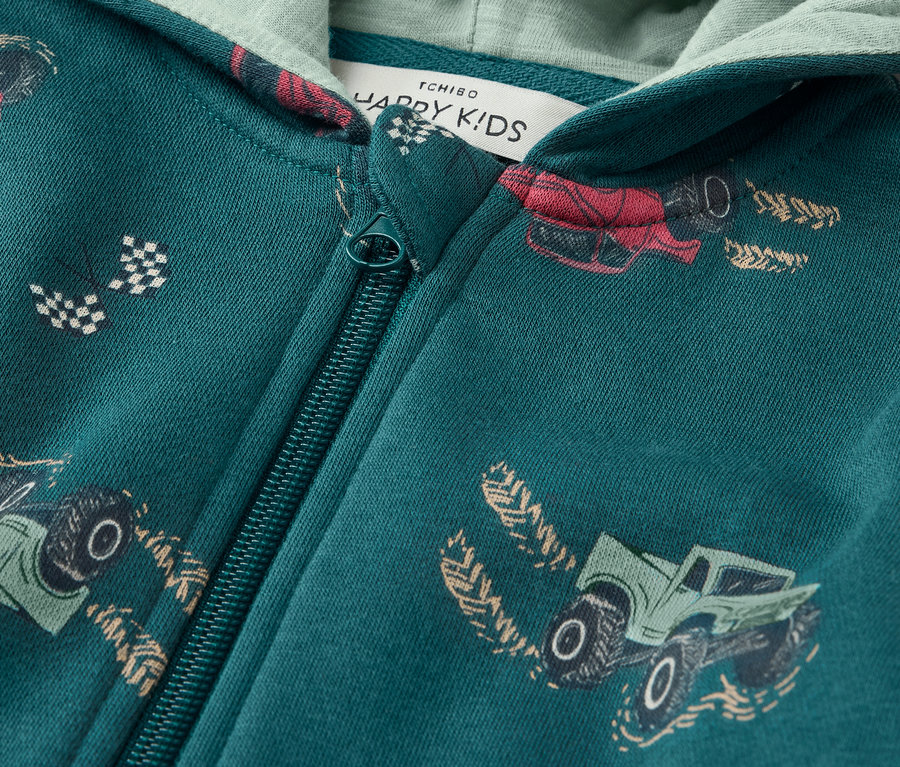 Detailansicht einer grünen Kinder-Sweatjacke mit Reissverschluss und Auto-Print.