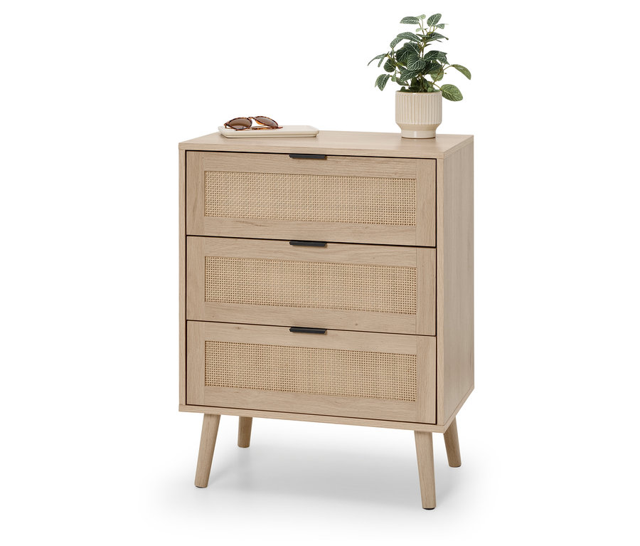 Eine Kommode mit drei Schubladen aus Rattan. Auf der Kommode liegen eine Sonnenbrille und eine kleine Pflanze.