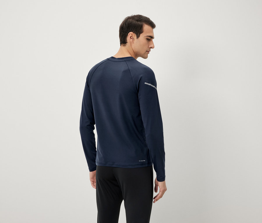 Mann von hinten in marineblauem Langarmshirt und schwarzen Hosen.