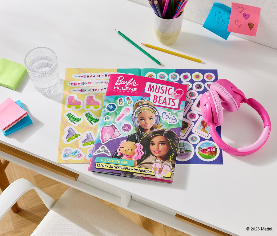 Auf einem Schreibtisch liegen pinke Kopfhörer neben einem Barbie-Malbuch, Aufkleberbogen, Stiften, Notizen und einem Glas Wasser.