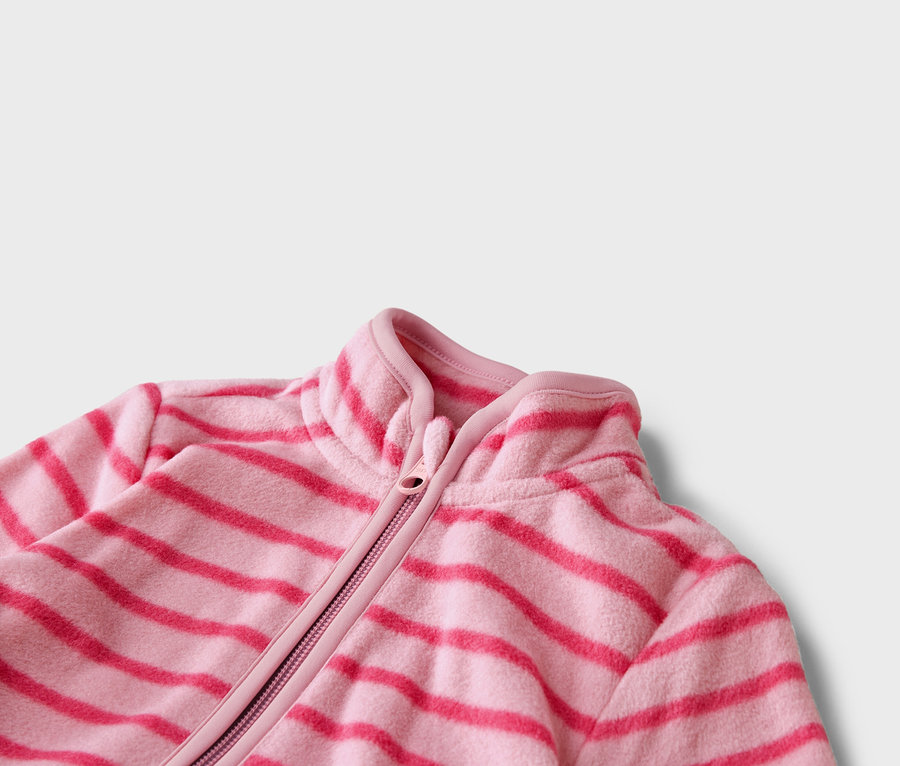 Nahaufnahme einer hellrosa Fleecejacke mit horizontalen dunkelrosa Streifen und Reißverschluss.