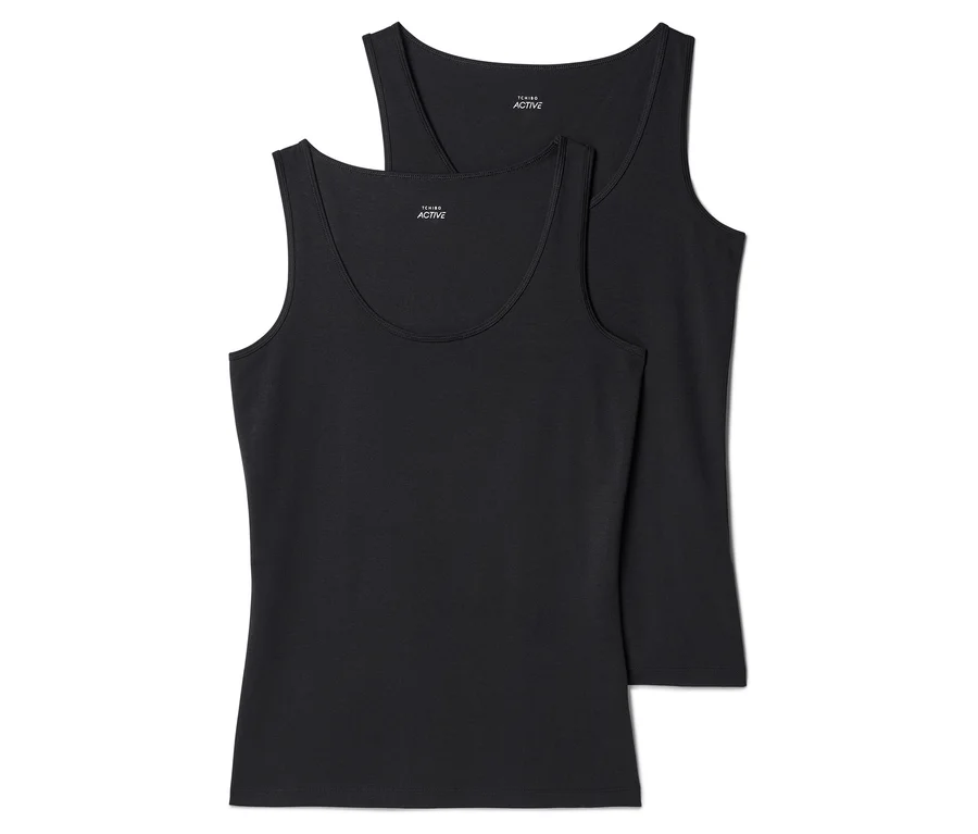 Zwei schwarze, ärmellose Tanktops liegen übereinander, wobei das obere Tanktop teilweise vom unteren verdeckt wird.