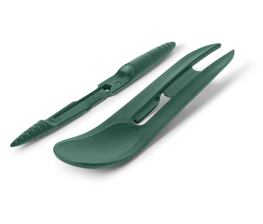 Ein grünes Divot-Reparaturwerkzeug und ein Golfball-Linienmarker liegen auf einem weißen Hintergrund.