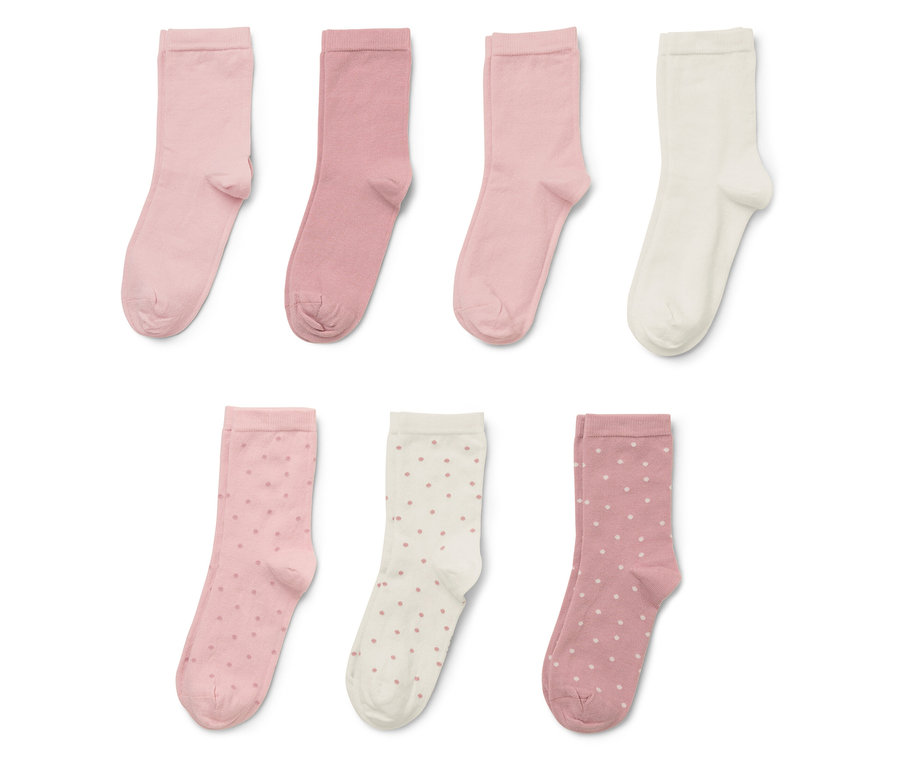 Sieben Socken in verschiedenen Rosa- und Cremetönen, einige mit Punktmuster.