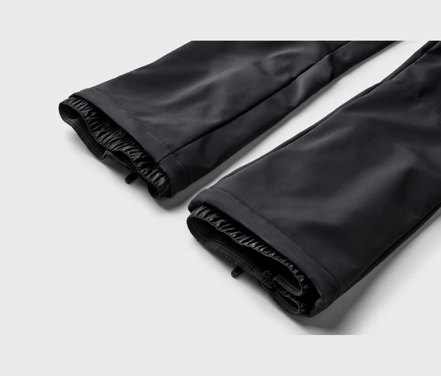 Zwei schwarze Hosenbeine mit elastischen Innenbündchen und glattem Stoff.