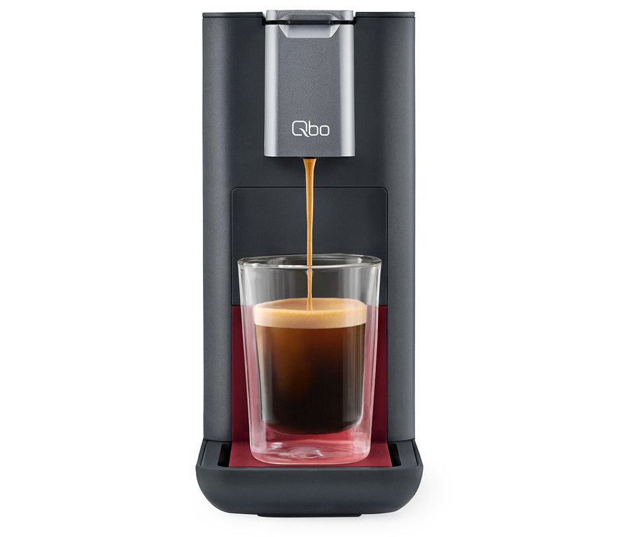 Kaffee fließt aus der Qbo ESSENTIAL Dark Berry Kaffeemaschine in ein Glas.