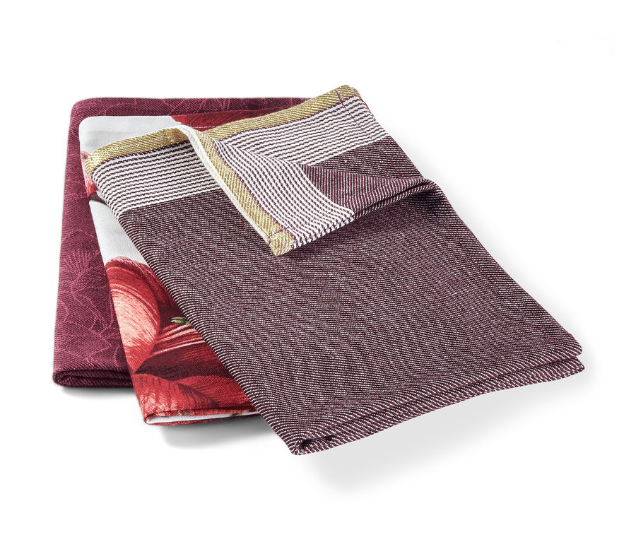 Drei Geschirrtücher liegen übereinander: eines ist bordeauxrot, eines hat ein Blumenmuster, eines hat Streifen.