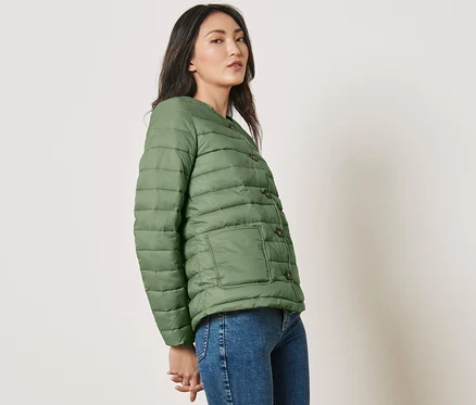 Frau posiert in grüner Steppjacke.