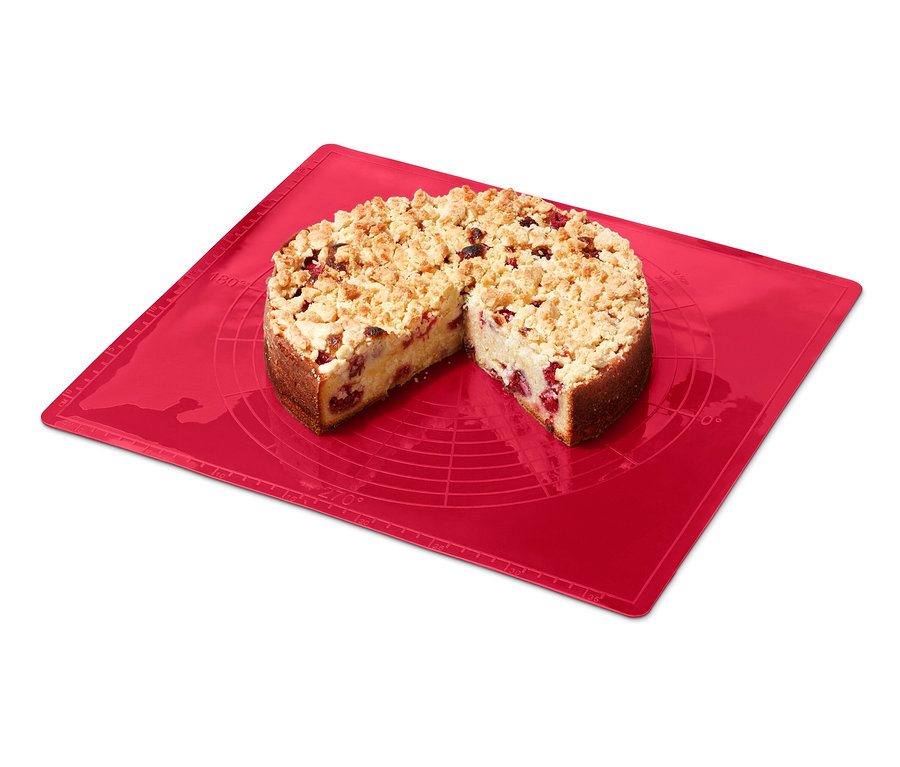 Ein Streuselkuchen, angeschnitten auf einer roten Dauerbackmatte.