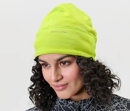 Frau trägt eine limefarbene Thermo-Funktionsmütze.