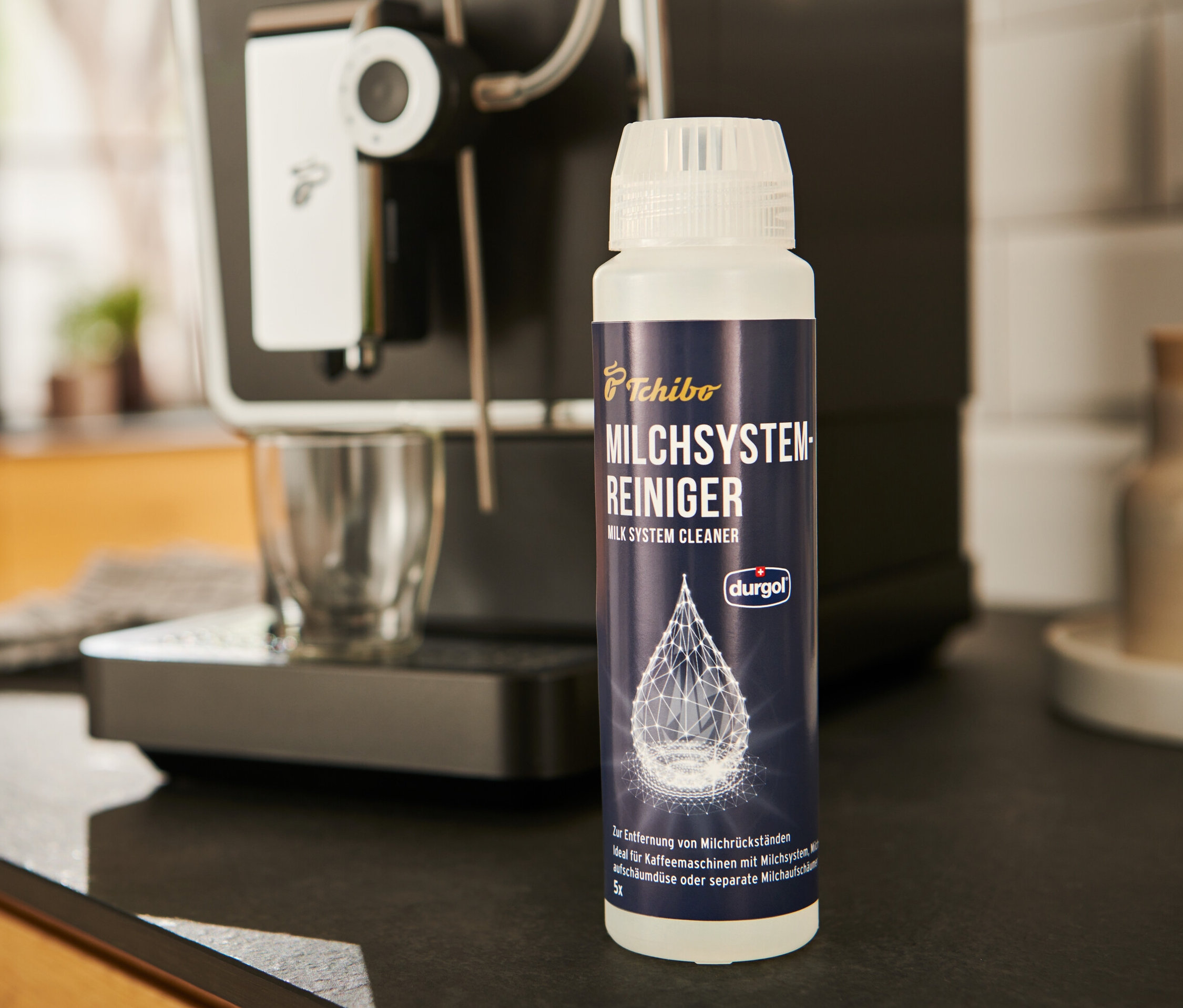 durgol® Milchsystem-Reiniger	, 250 ml steht neben einer Kaffeemaschine.