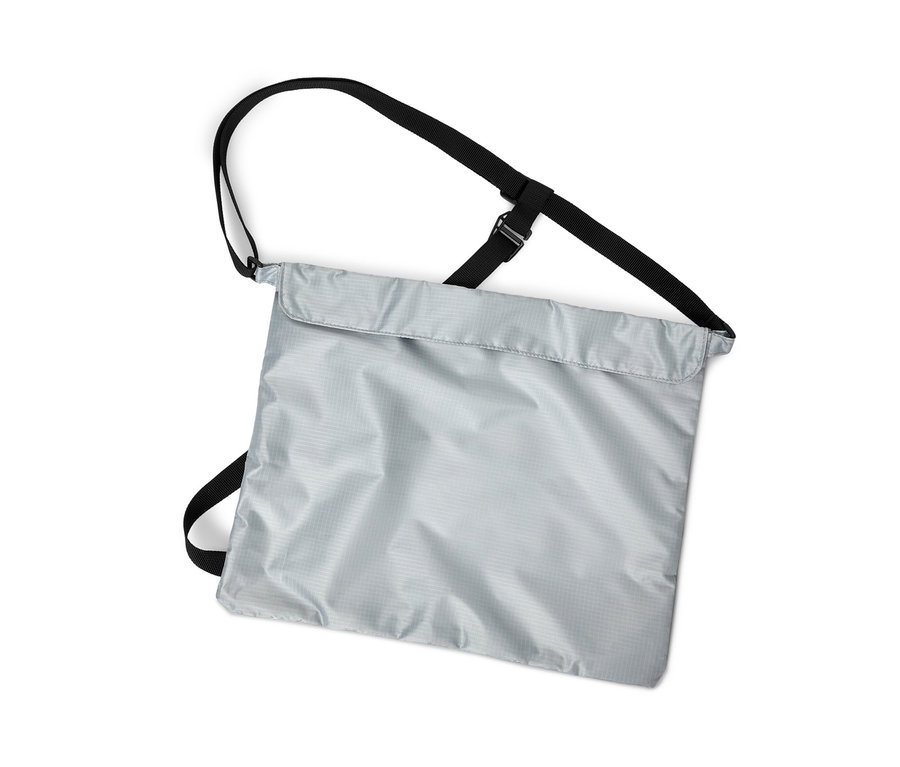 Vertikale Aufnahme einer silbernen Fahrrad-Einkaufstasche mit schwarzen Riemen auf weißem Hintergrund.