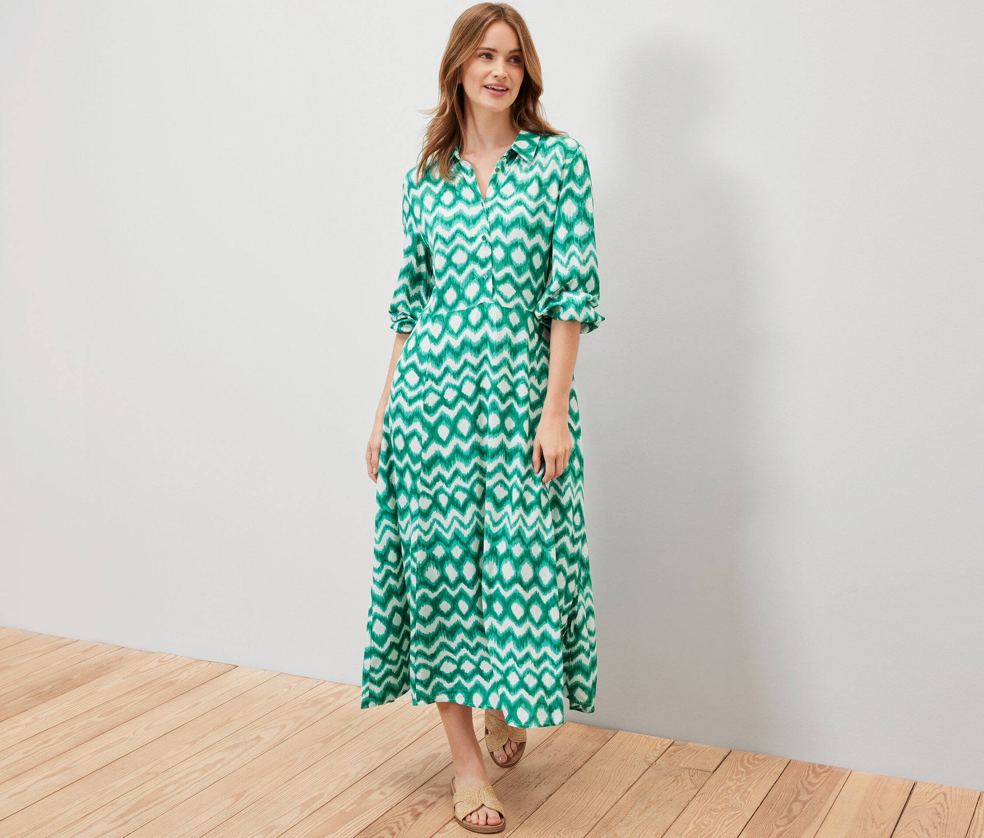 Frau posiert in einem grün bedruckten Hemdblusenkleid.