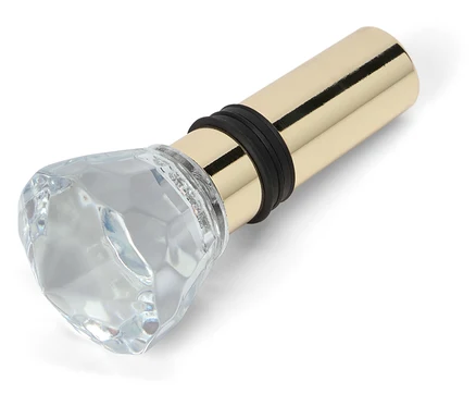 Flaschenverschluss mit rautenförmigem Glasaufsatz und goldenem Metallsockel.