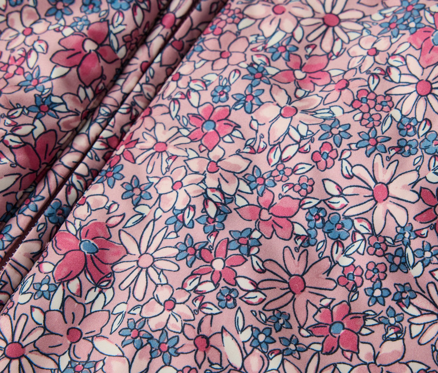 Detailansicht eines Baby-Winteroveralls mit Blumenmuster.