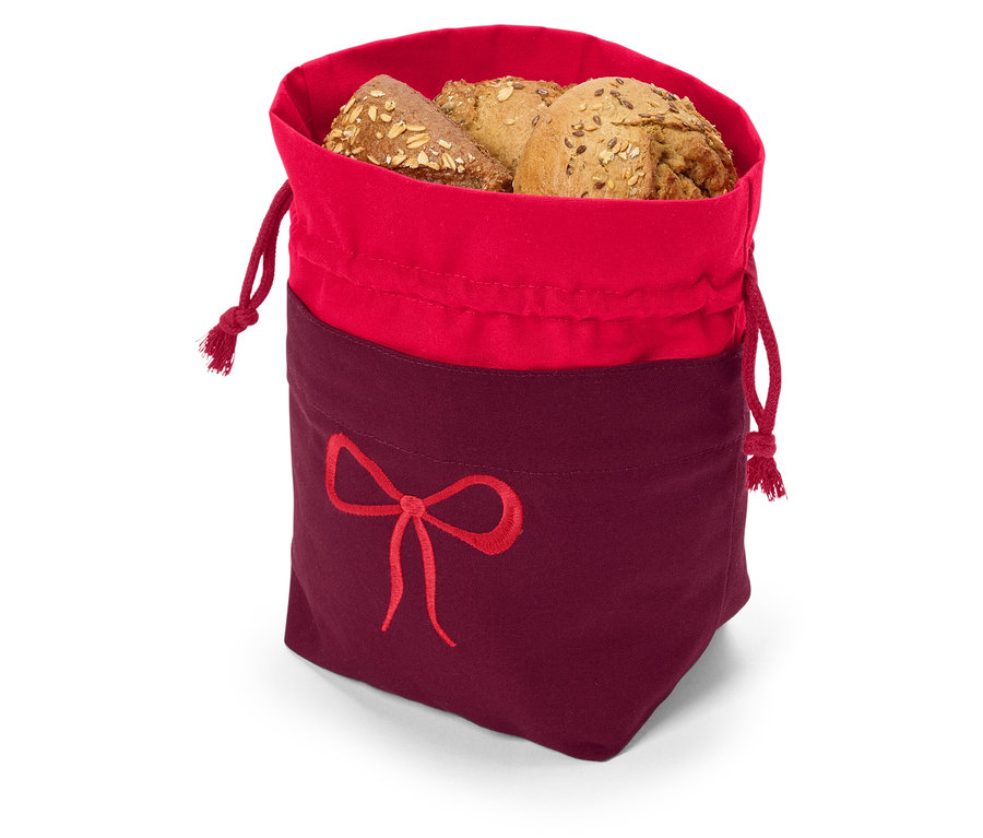 Mehrkornbrot in einem rot-burgunderfarbenen Stoffbeutel mit Kordelzug und Schleifenstickerei.