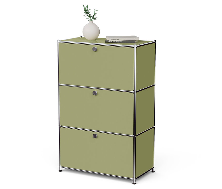 Ein grüner Schrank mit drei Schubladen, auf dem eine Vase mit einer Pflanze und ein Buch stehen.