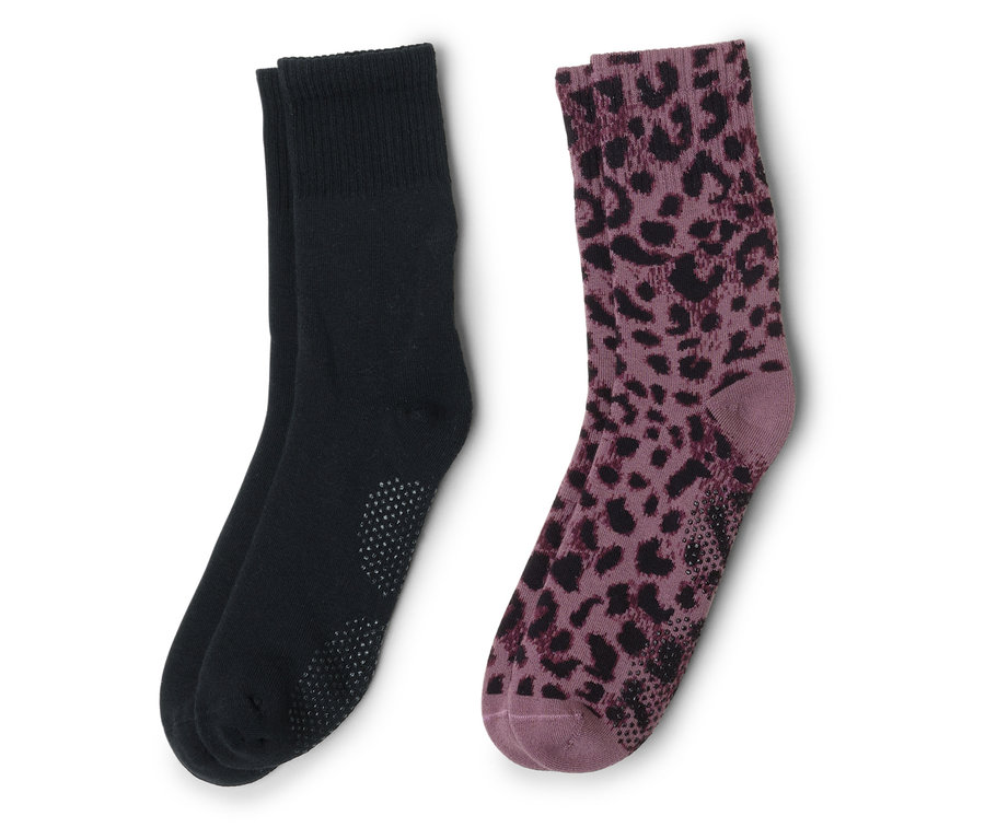 Zwei Socken liegen nebeneinander, eine schwarz mit Noppen, die andere lila mit schwarzem Leopardenmuster.