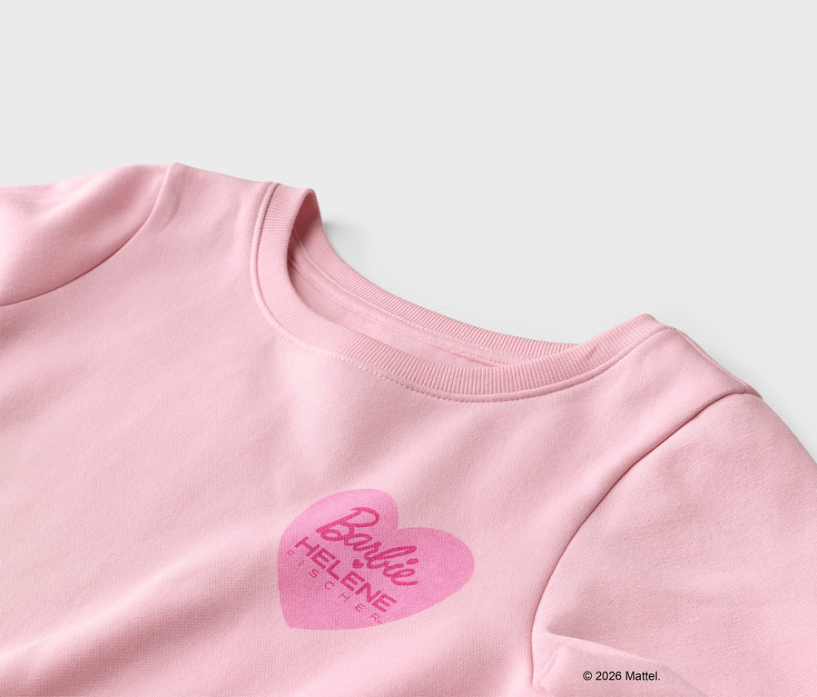 Detailansicht eines rosa Sweatshirts mit einem Herzaufdruck mit dem Barbie-Logo und dem Namen Helene Fischer.
