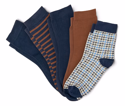 Fünf Paar Socken, darunter zwei einfarbige marineblaue, eine marineblaue mit braunen Streifen, eine einfarbige braune und eine weiße mit blauem Hahnentrittmuster.