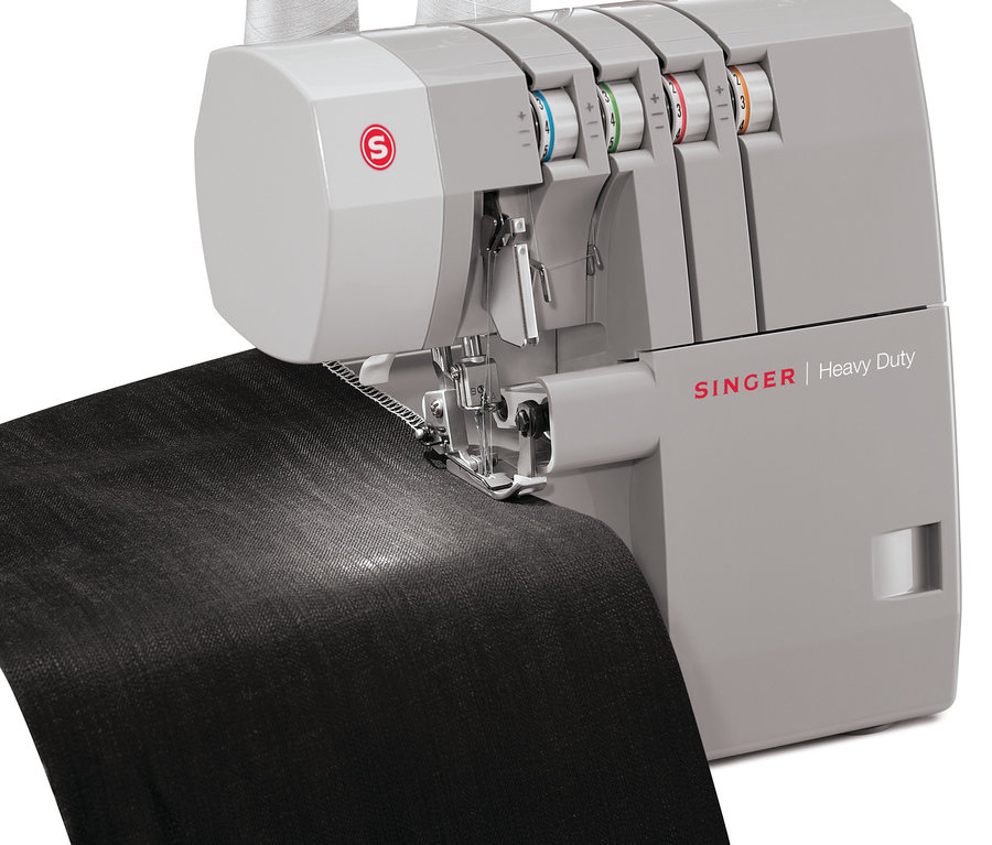 Detailaufnahme einer grauen SINGER® Overlock-Nähmaschine »Heavy Duty 14HD854«, die schwarzen Stoff näht.
