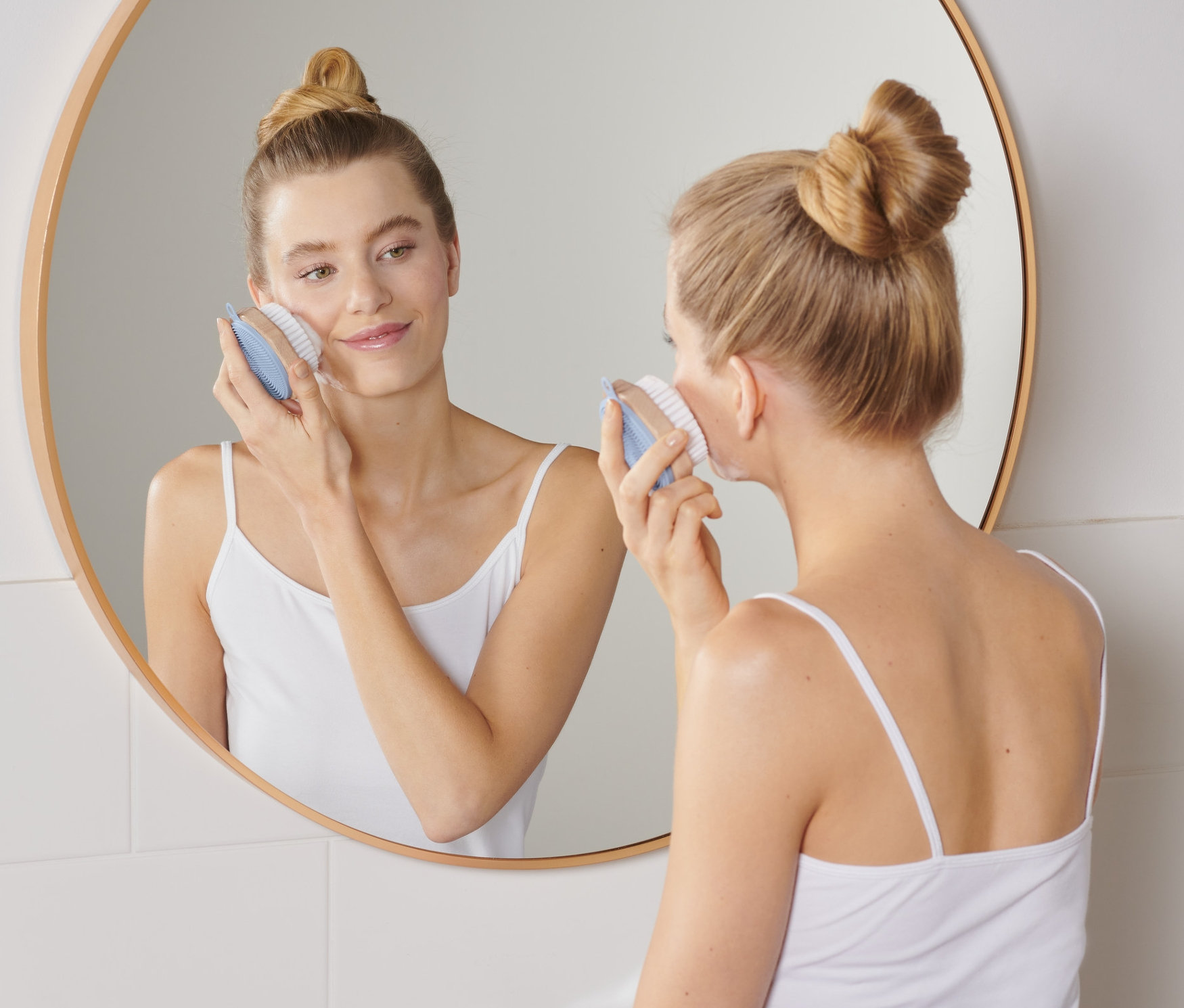 Frau verwendet eine Gesichtsreinigungsbürste.