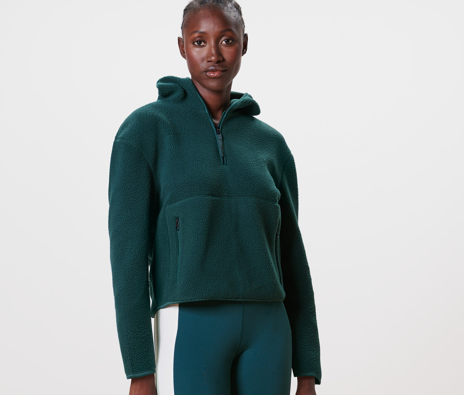 Frau trägt einen Teddy-Kapuzenpullover, dunkelgrün.