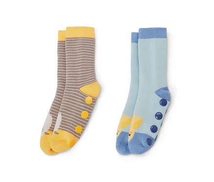 Zwei Paar Kinder-Antirutsch-Socken. Ein Paar ist braun-weiß gestreift mit gelben Akzenten und Vogelbild, das andere Paar ist hellblau mit Giraffenbild und dunkelblauen Punkten.