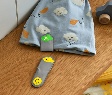 Blaue Mütze mit Wolkenmuster und 2 LED-Magnet-Lichter »Wolken« liegen auf einem Regal.